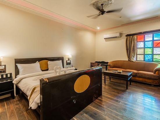an image of a bedroom with a living space and a fan hanging from the ceiling.